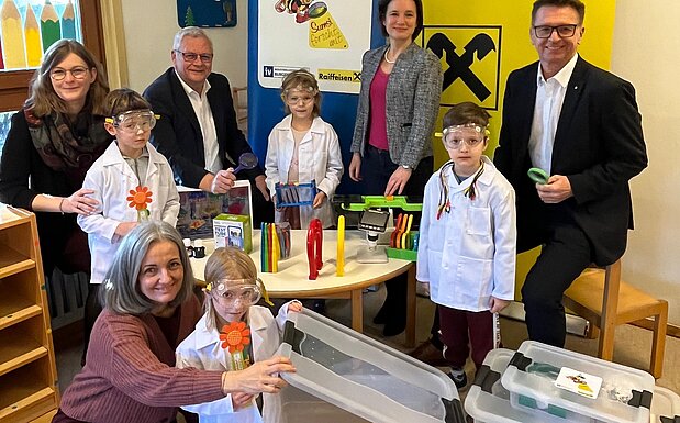 Übergabe der Sumsi-Forscherbox an den Kindergarten Kirchäcker in Eisenstadt mit Pädagogin Carina Sommer, Kindergartenleiterin Julia Prinke, Bürgermeister Thomas Steiner, IV-Burgenland Geschäftsführerin Aniko Benkö und Vorstandsdirektor der Raiffeisenlandesbank Burgenland Rudolf Suttner sowie Kindern des Kindergartens.