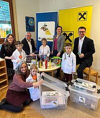 Übergabe der Sumsi-Forscherbox an den Kindergarten Kirchäcker in Eisenstadt mit Pädagogin Carina Sommer, Kindergartenleiterin Julia Prinke, Bürgermeister Thomas Steiner, IV-Burgenland Geschäftsführerin Aniko Benkö und Vorstandsdirektor der Raiffeisenlandesbank Burgenland Rudolf Suttner sowie Kindern des Kindergartens.